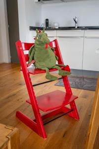 a frog sitting in a red chair in a kitchen at Schwarzhornblick in Grächen