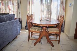 a wooden table and chairs in a living room at Razz Homes in Diani Beach