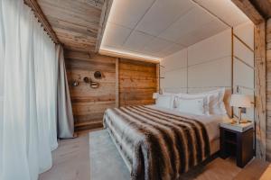 a bedroom with a bed in a room with wooden walls at Ultima Hotel Courchevel in Courchevel
