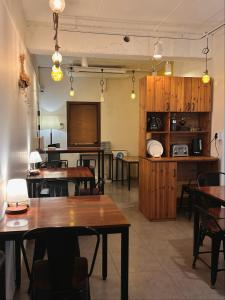 a room with tables and chairs and a kitchen at Hostel Espace in Chuncheon
