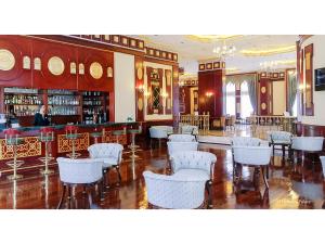 un restaurante con sillas blancas y un bar en Meyra Palace, en Ankara