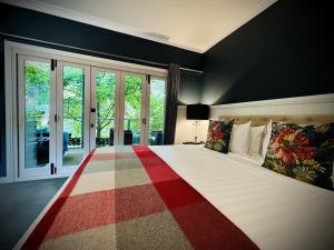 a bedroom with a large bed with a red and white blanket at The Dudley Boutique Hotel in Daylesford +39 photos