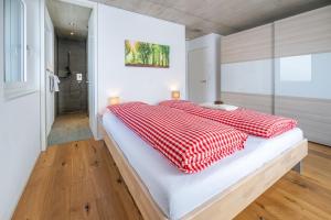 a bedroom with a bed with red and white blankets at Schwarzhornblick in Grächen