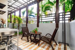 a balcony with a table and chairs and a sink at Ban Kong Rao Guesthouse - Quiet Santitham Oasis - Charming Garden & Mountain Views in Chiang Mai