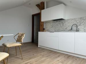 a kitchen with white cabinets and a table and chairs at Villa Speranza Kościelna Droga 12 in Łomianki Dolne