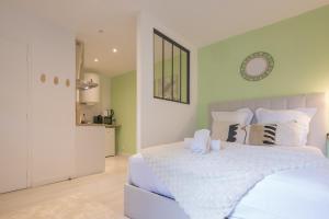 a bedroom with a bed with white sheets and pillows at Le Nid Vert - air conditioning - ground floor in Bourg-en-Bresse
