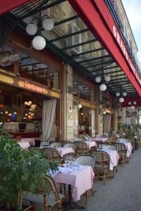 an outdoor restaurant with tables and chairs with pink tables at Le Nid Vert - air conditioning - ground floor in Bourg-en-Bresse