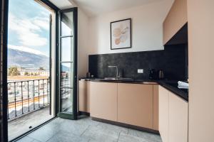 a kitchen with a sink and a large window at Cà del Lasco - Free parking apartments 5 min from the station in Bellano
