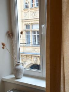 a vase on a window sill with a view of a building at Grazerhof in Graz