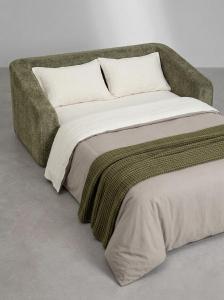 a bed with a green blanket and pillows on it at Grazerhof in Graz +70 photos