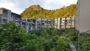 a row of apartment buildings in front of a mountain at The Valley Khaoyai by NPP in Phayayen