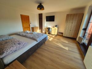 a bedroom with a bed and a wooden floor at Penzion Kostelany in Kostelany