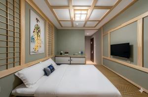 a bedroom with a large bed and a flat screen tv at Inner Mongolia Hotel Beijing - 300m to CUC Metro, Easy Access to Forbidden City & Universal Studios in Beijing