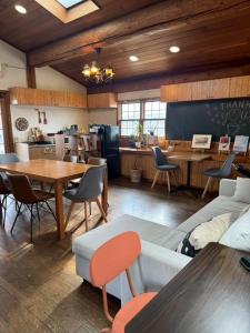 a living room with a table and chairs and a classroom at Attico Inn ムーミン公園近く in Hanno