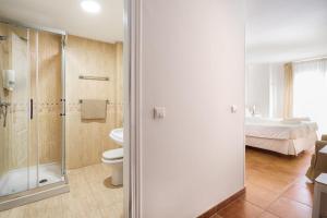 a bathroom with a shower and a toilet and a bed at Apartamentos Capricho del Mar in Torremolinos +113 photos