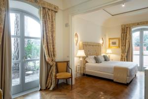 a bedroom with a bed and a large window at Relais Villa San Martino in Martina Franca +90 photos
