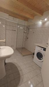 a bathroom with a sink and a washing machine at Marigold in Riva del Garda +25 photos