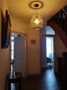 a room with a hallway with a chandelier and a door at Les Ombelles in Saint-Estèphe