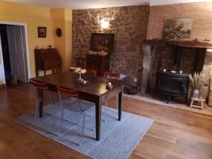 a dining room with a table and a fireplace at Les Ombelles in Saint-Estèphe