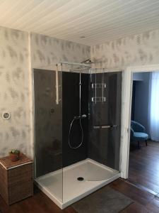 a shower with a glass enclosure in a room at Les Ombelles in Saint-Estèphe