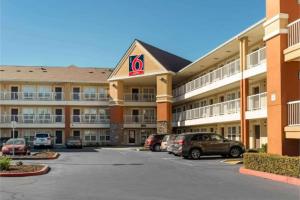 a large hotel with cars parked in a parking lot at Studio 6 Extended Stay Sacramento Arden Way CA in Sacramento