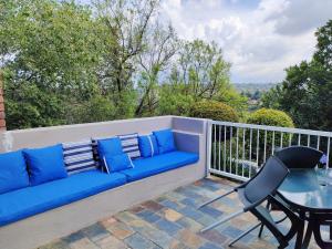 a blue couch and a table on a balcony at Sunset on Silver Beautiful self catering Studio apt in Roodepoort +8 photos