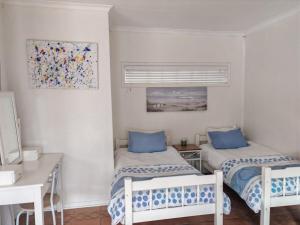 a room with two beds with blue pillows in it at Sunset on Silver Beautiful self catering Studio apt in Roodepoort