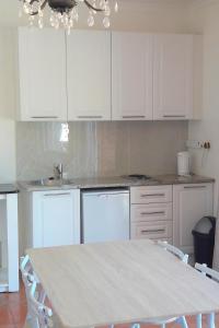 a kitchen with white cabinets and a table with chairs at Sunset on Silver Beautiful self catering Studio apt in Roodepoort