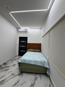a bedroom with a bed in a room with marble floors at suites ejecutivas centro guadalupe in Monterrey