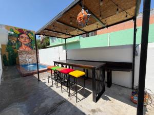 a patio with a table and stools in front of a mural at suites ejecutivas centro guadalupe in Monterrey
