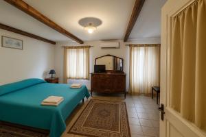 a bedroom with a blue bed and a mirror at Albergo Diffuso Borgo Santa Caterina "Vintage" in Castiglione di Sicilia