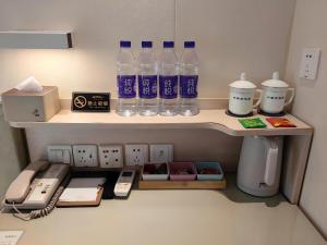 a shelf with bottles of water and other items on it at Inner Mongolia Hotel Beijing - 300m to CUC Metro, Easy Access to Forbidden City & Universal Studios in Beijing