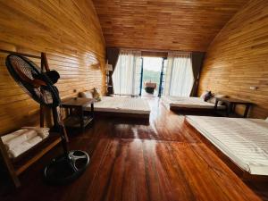 a room with two beds and a wooden wall at Maisonson Resort in Dương Kê