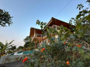 a house on a hill with flowers in the foreground at Maisonson Resort in Dương Kê