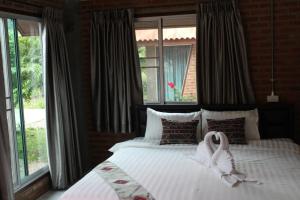 a bedroom with a bed with a swan on it at MatanaCafe&Resort in Ban Bo Nam Khao