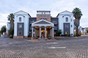a building on a street with palm trees at Basdenwood Hotel in Centurion