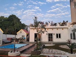 a house with a swimming pool in front of it at Asmi by Beal's Farm in Jaipur +30 photos
