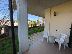two white chairs sitting on the porch of a house at Ami Affittacamere 2 in Castel San Giovanni