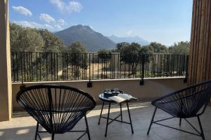 two chairs and a table on a balcony with mountains at Residence I Pozzi in Belgodère +49 photos