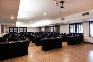 a room with rows of tables and chairs at Basdenwood Hotel in Centurion
