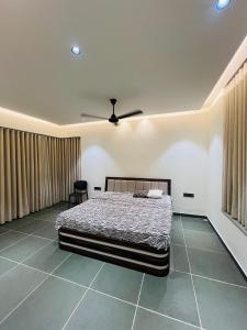 a bedroom with a bed and a ceiling fan at Weekend villa in Rajkot