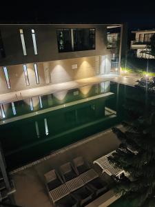 a view of a building with a swimming pool at night at Weekend villa in Rajkot