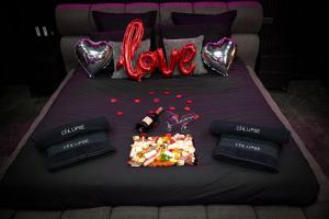 a bed with the word love spelled out on it at L'Eclipse - Exceptional SPA Suite, sauna and hammam in Douai +62 photos