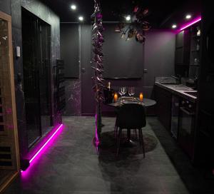a kitchen with purple lighting and a table in a room at L'Eclipse - Exceptional SPA Suite, sauna and hammam in Douai