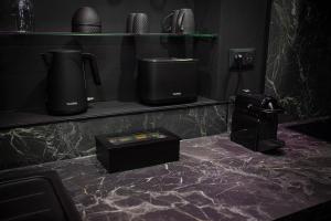 a black marble counter top with two appliances on it at L'Eclipse - Exceptional SPA Suite, sauna and hammam in Douai