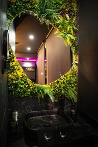 a bathroom with a mirror and a sink with plants at L'Eclipse - Exceptional SPA Suite, sauna and hammam in Douai