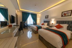 a hotel room with two beds and a television at Petra Canyon Hotel in Wadi Musa +27 photos