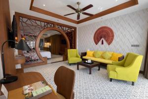 a living room with a yellow couch and chairs at Koi Resort & Spa Hoi An in Hoi An