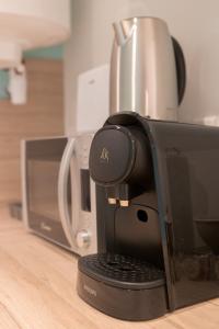 a coffeemaker sitting on a counter next to a microwave at La Perle Bleue - air conditioning - ground floor in Bourg-en-Bresse