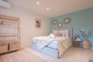 a bedroom with a white bed and a blue wall at La Perle Bleue - air conditioning - ground floor in Bourg-en-Bresse